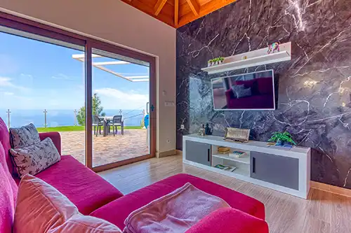 Salon et salle à manger de la Casa Yaneric avec canapé, TV et portes-fenêtres