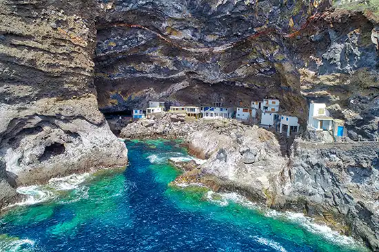 Drohnenblick in den Proís de Candelaria: Höhlenöffnung, Meer und Siedlung – La Palma