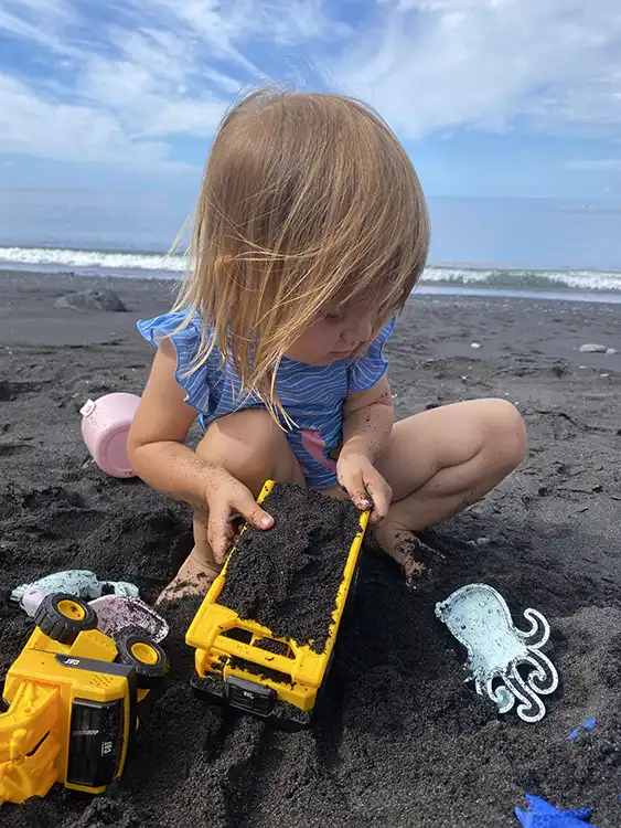 Niño pequeño jugando en la arena en la playa de La Palma